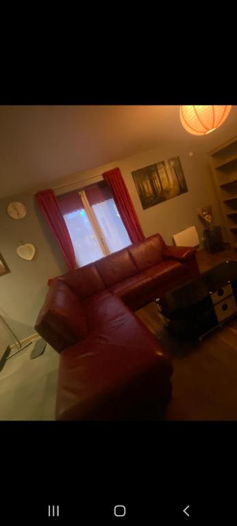 a living room with a couch and a window at Maisonette de plain pied à 5 à pied de la gare de denain. in Denain