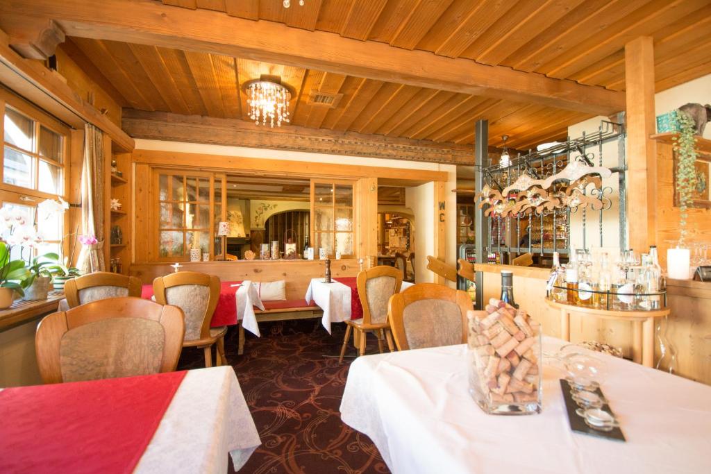 restauracja ze stołami, krzesłami i lustrem w obiekcie Hotel Soliva w mieście Sedrun