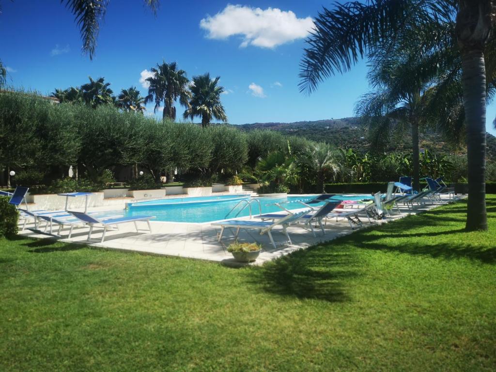 una piscina en un complejo con palmeras en La casa di Giorgia a Capo Vaticano, en Capo Vaticano