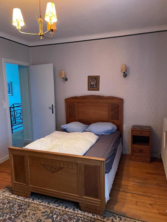 Location maison à Chadron : Haute Loire : غرفة نوم مع سرير خشبي كبير في غرفة