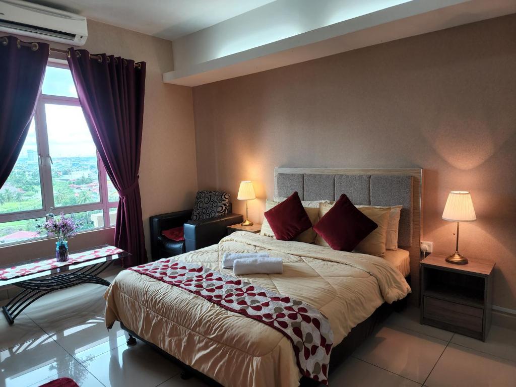 um quarto com uma cama grande e almofadas vermelhas em The Viana Apartment 1 em Kota Bharu