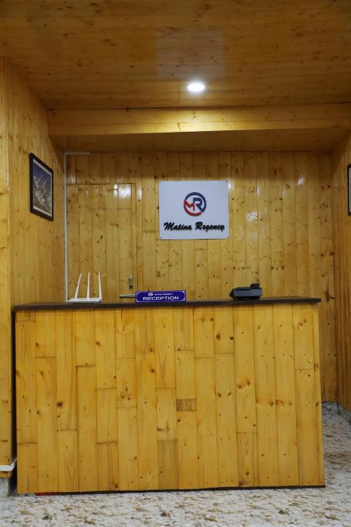 a room with a wooden wall with a sign on it at Matina Regency in Gangtok