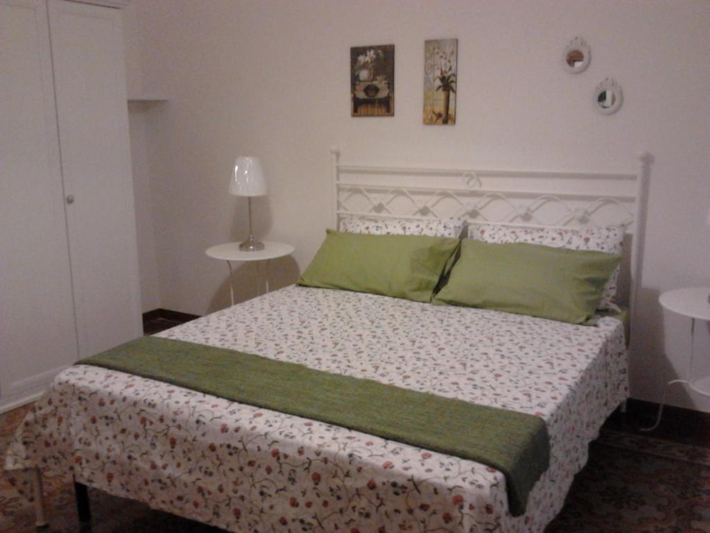 a bedroom with a bed with green pillows at Casa Vacanza Le Farfalle in Trapani