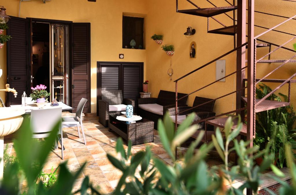 a patio with a table and chairs and a staircase at L’elegante dépendance del Barone Francesco Sala in Agrigento