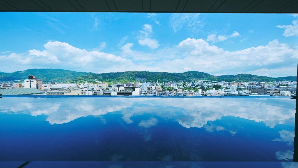 a large pool of water with a city in the background at Sora Niwa Terrace Kyoto in Kyoto