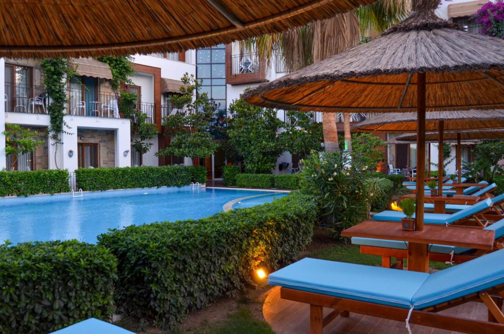 a resort with a swimming pool with chairs and umbrellas at Liona Hotel & SPA in Gundogan