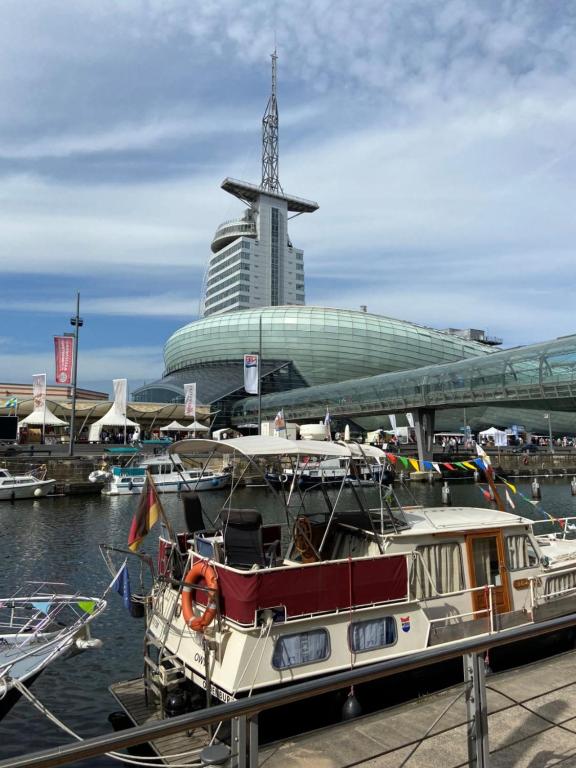 una barca ormeggiata in un molo con un grande edificio di Ferienwohnung Weserblick Hundertwasser a Bremerhaven