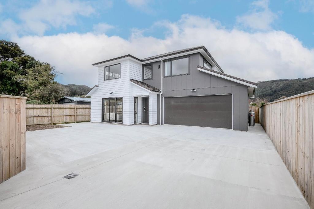 una casa blanca con garaje en Newly built house, en Lower Hutt