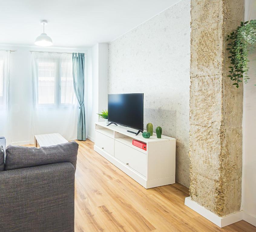una sala de estar con TV en un armario blanco en CARTAGENAFLATS, Apartamentos Anfiteatro Romano 4C en Cartagena