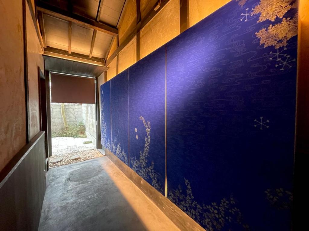 un pasillo con una pared azul y una ventana en 橋旅西雅院 Kyoryosaiga Inn, en Kioto