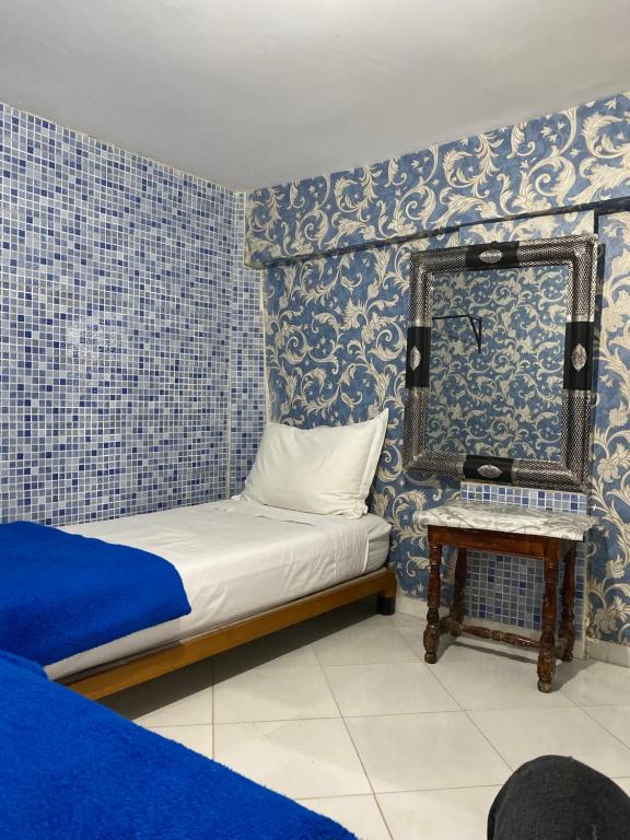 małą sypialnię z łóżkiem i lustrem w obiekcie Hostel Essassi 23 w Marakeszu