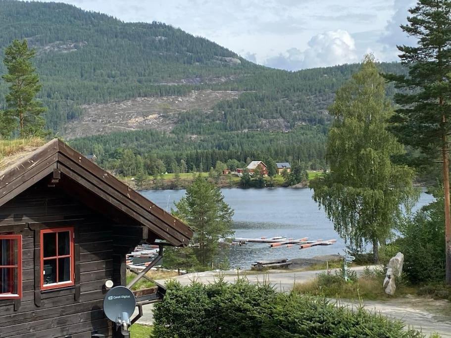 a log cabin with a view of a lake at Laftet hytte i strandkanten med bade og fiske muligheter in Vradal