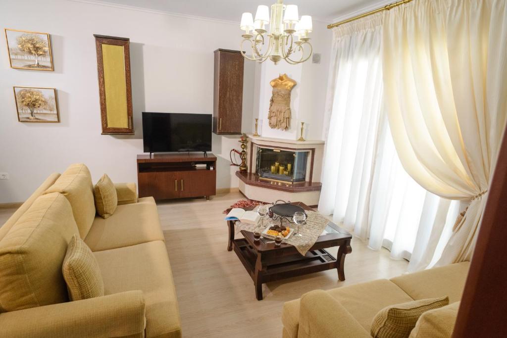a living room with a couch and a tv at Luxury Dafnis House in Veria