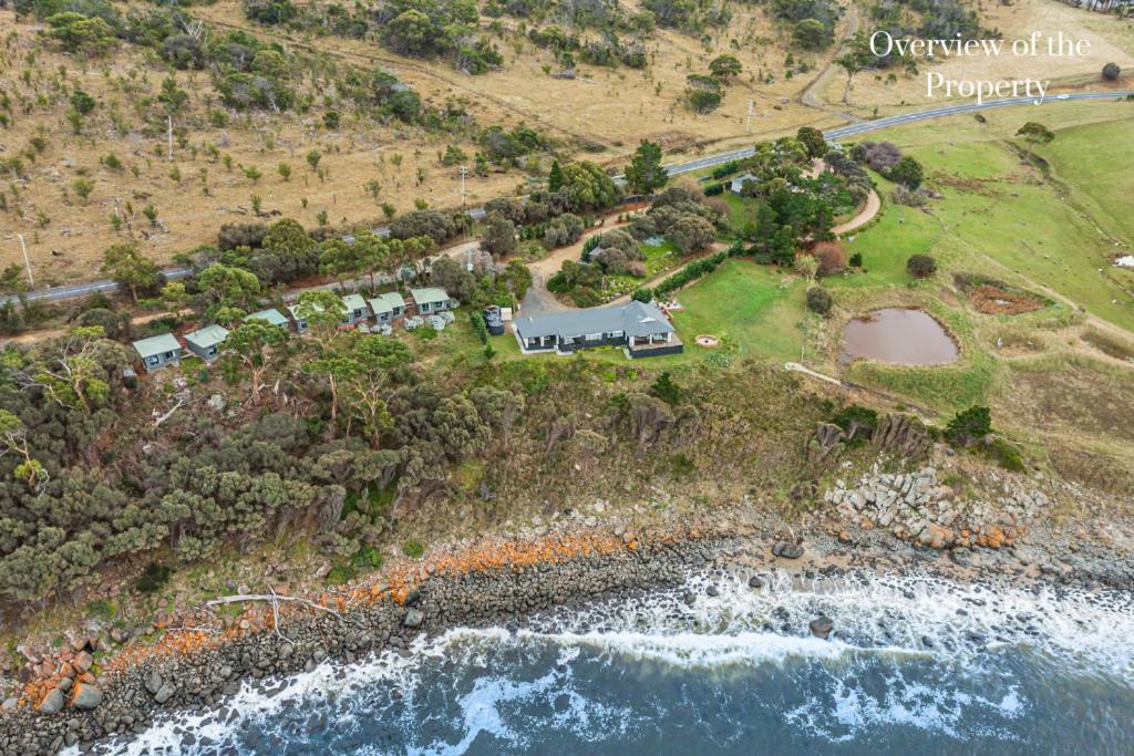 an aerial view of a house on a hill next to the ocean at Hamptons on the Bay in Swansea