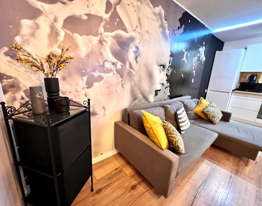 a living room with a couch and a wall mural at GOOD PLACE 4U Apartament na Jurze in Zawiercie