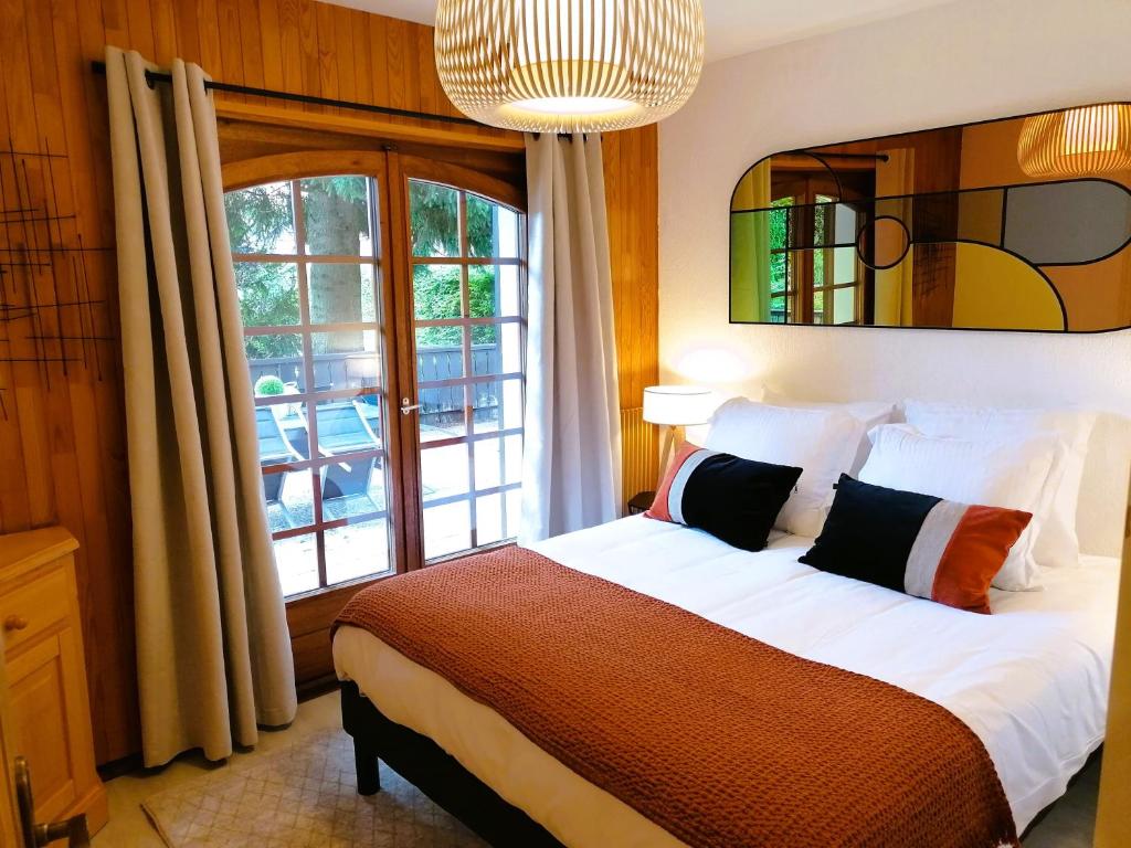 Un dormitorio con una cama y una ventana grande. en Appartement Helios, en Les Gets