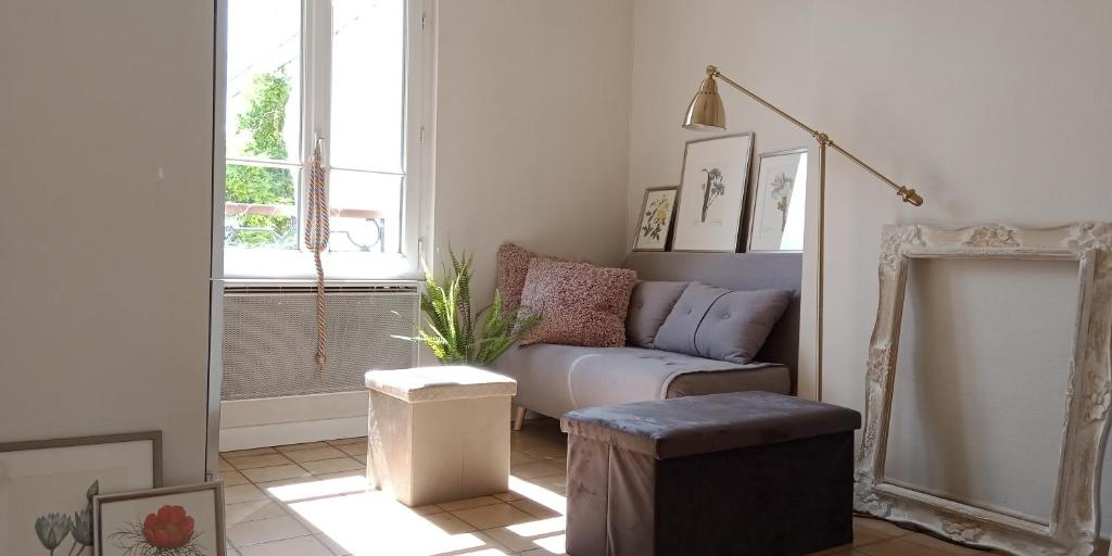 a living room with a couch and a window at PARIS AUTHENTIC HOUSE Small, bright and calm studio in Paris