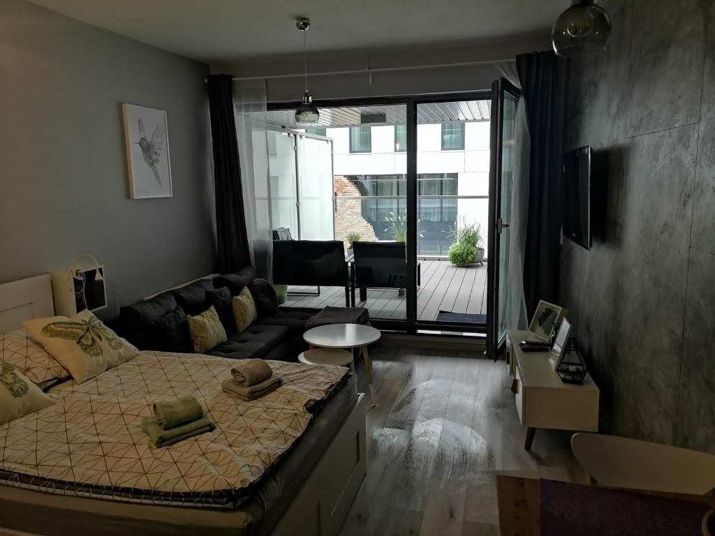 ein Schlafzimmer mit einem Bett und einem Sofa sowie ein Wohnzimmer in der Unterkunft Apartament Gran nad Motławą in Danzig