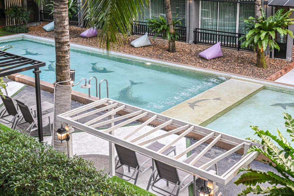 a large swimming pool with chairs and a table at Aranta Suvarnabhumi in Lat Krabang