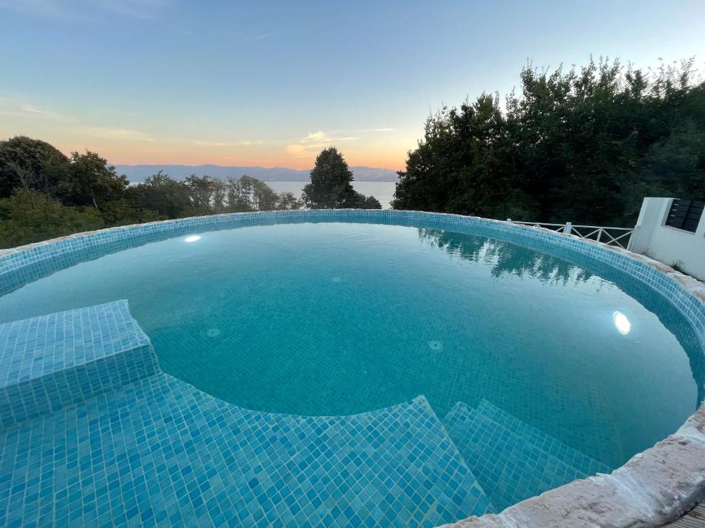 a large blue swimming pool with a sunset in the background at Minihane Sapanca in Sapanca