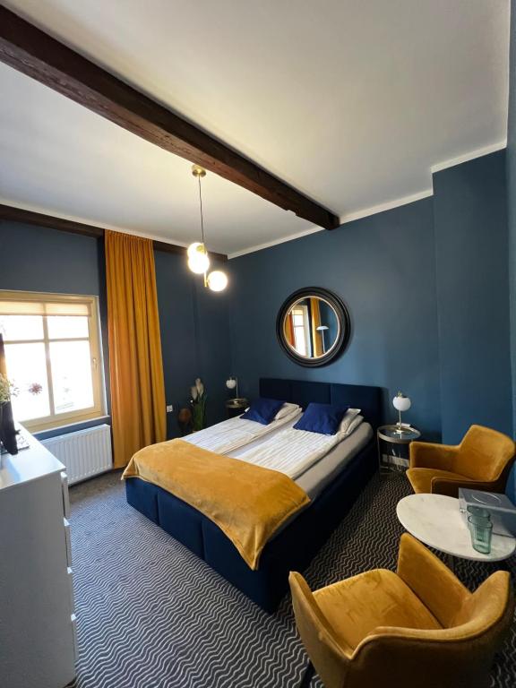 sypialnia z łóżkiem, lustrem i krzesłami w obiekcie CIENISTA 7 APARTMENTS w mieście Lądek-Zdrój