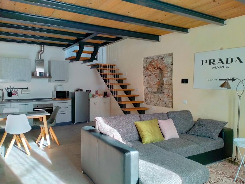 a living room with a couch and a kitchen at Maison Cascina Amélie in Abbadia Lariana