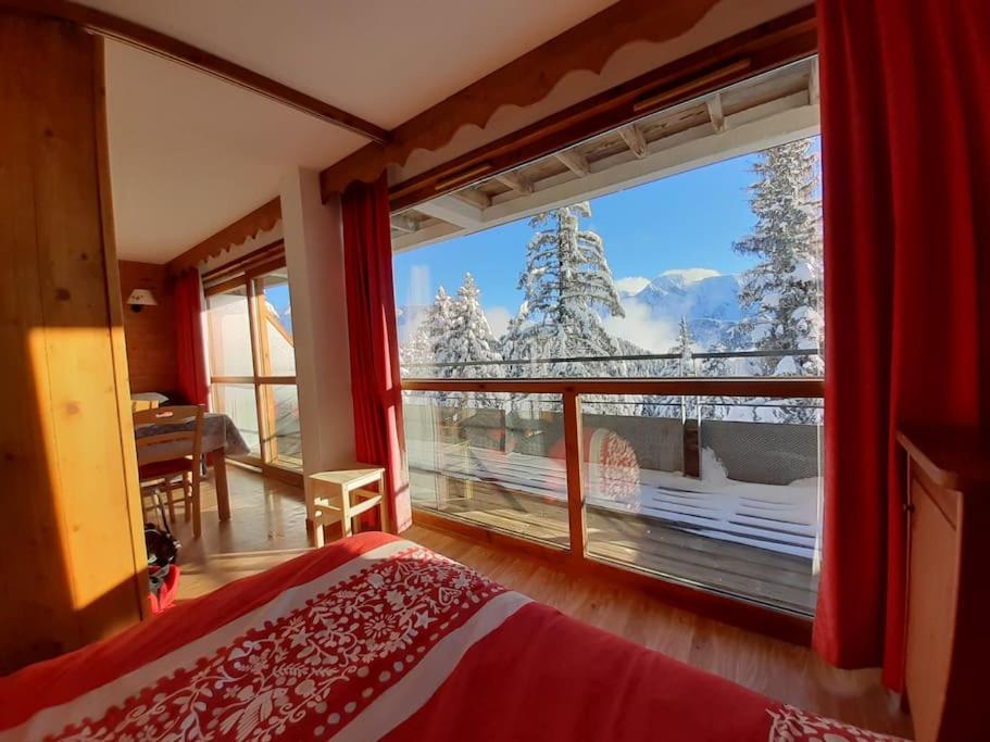 una camera da letto con una grande finestra con vista su una montagna di Superbe appartement Chamrousse près des pistes a Chamrousse