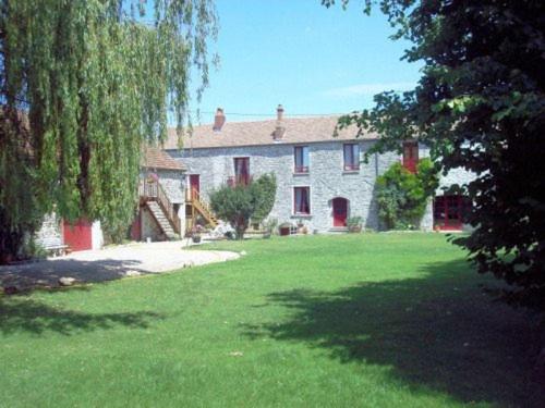 een groot huis met een tuin met groen gras bij La Picardière in Perdreauville