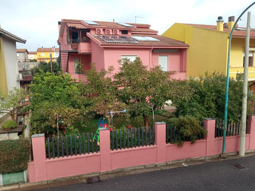 une clôture rose devant une maison dans l'établissement Corona Bed & Breakfast, à Sardara