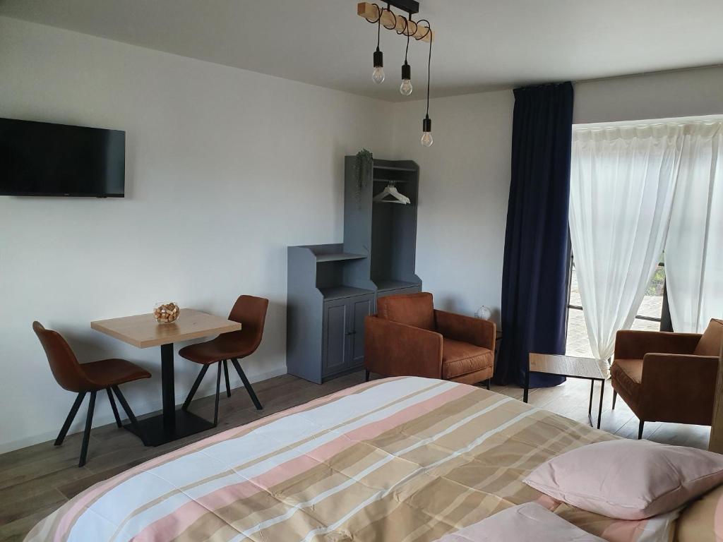 Pepingen的住宿－B&B Dekorn，卧室配有一张床和一张桌子及椅子