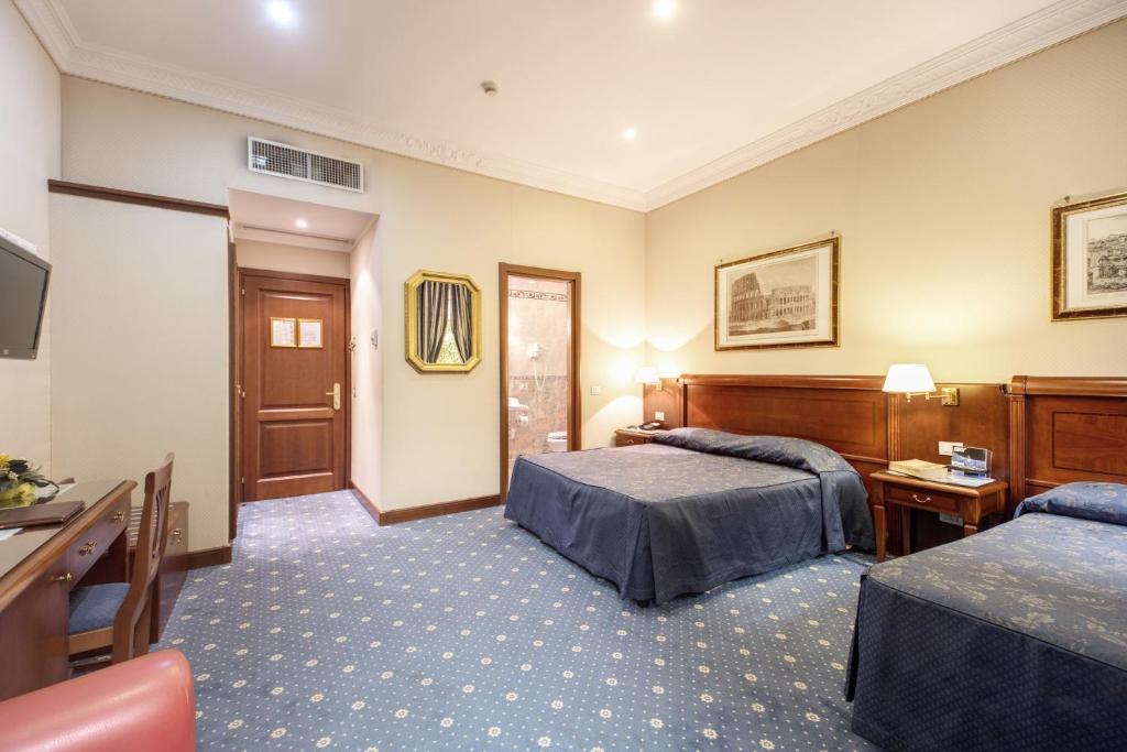 pokój hotelowy z 2 łóżkami i telewizorem w obiekcie Hotel Artorius w Rzymie