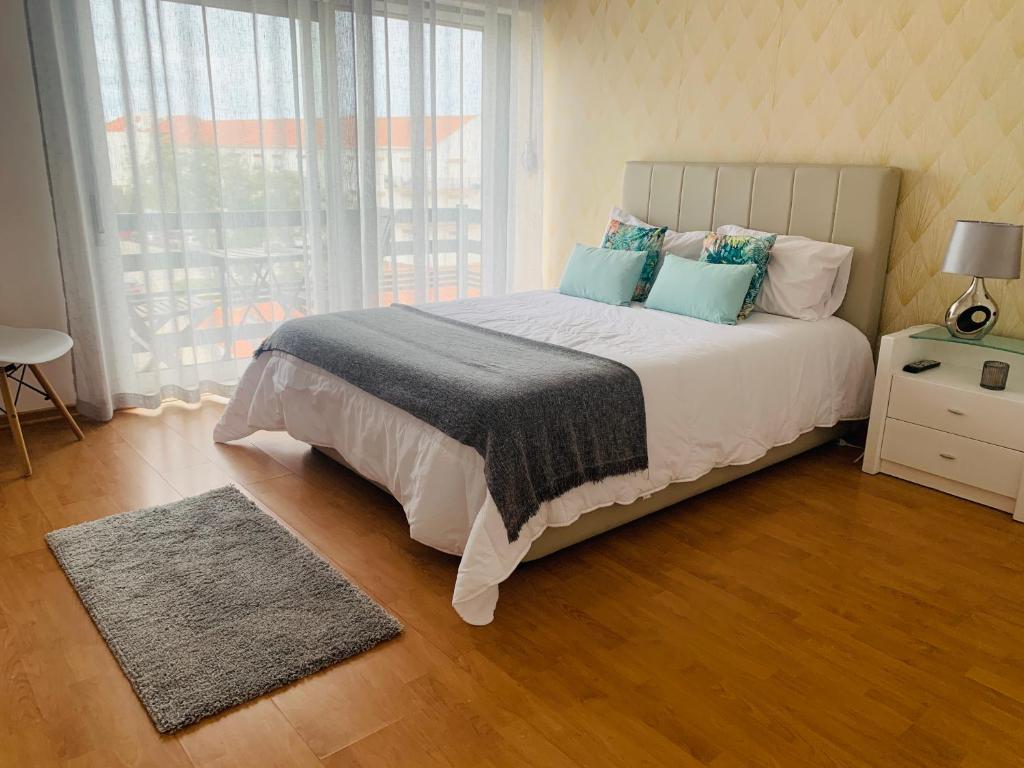Un dormitorio con una cama grande y una ventana. en CASA MR, en Nazaré