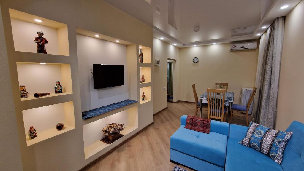 a living room with a blue couch and a television at LT-Home in Tbilisi City