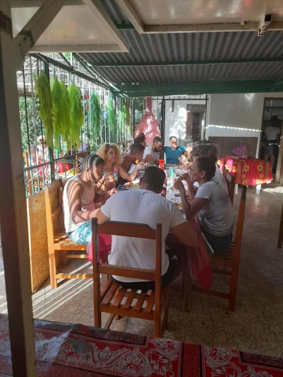 un gruppo di persone seduti intorno a un tavolo in un ristorante di Pam de Terra a Calheta