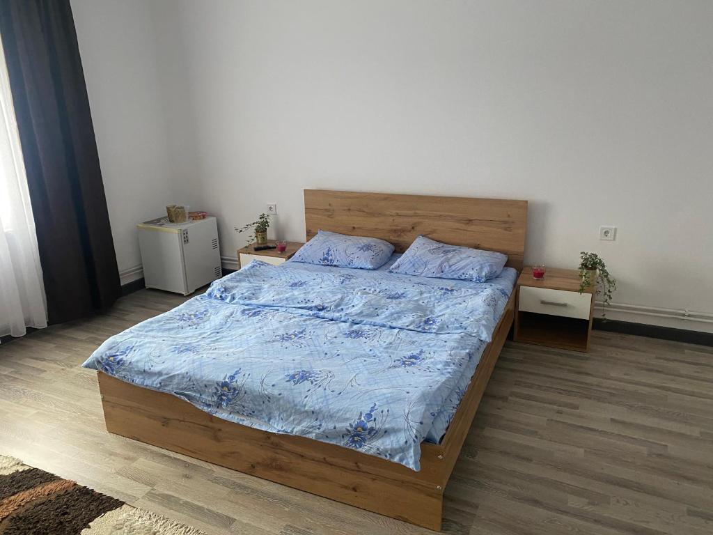 a bedroom with a wooden bed with a blue comforter at Casa Zeus in Seini