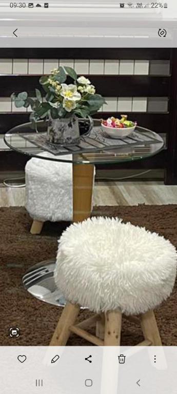 een salontafel met een witte kruk en een tafel met een glazen tafel bij ANASTASIJAKOP in Kopaonik