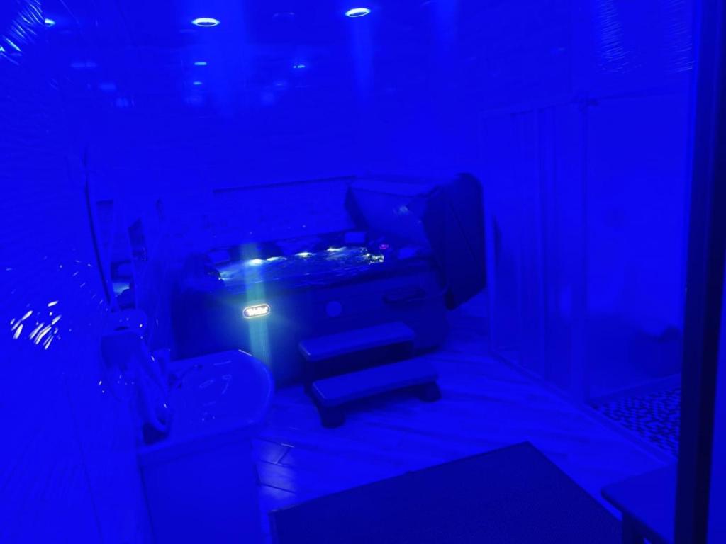 a dark room with a toilet and a blue light at Mieliausioji Dzekusi in Vilainiai