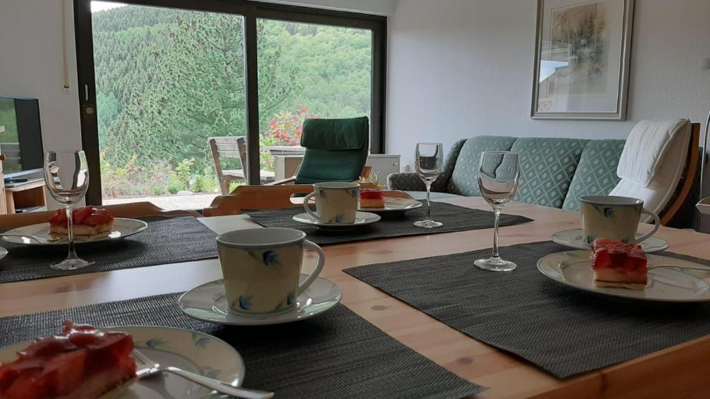 una mesa de comedor con platos de comida y copas de vino en Ferienwohnung Waldblick Winterberg, en Winterberg