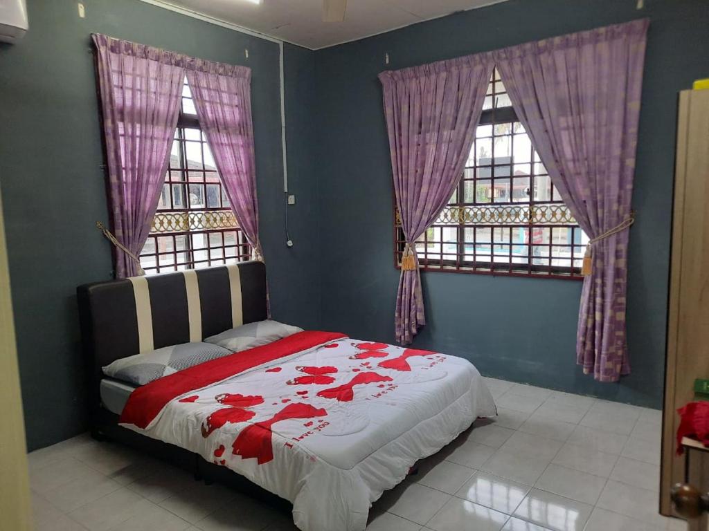 um quarto com uma cama com flores vermelhas em Jerai Geopark Cottage 3 bedrooms -Pulau Bunting em Yan