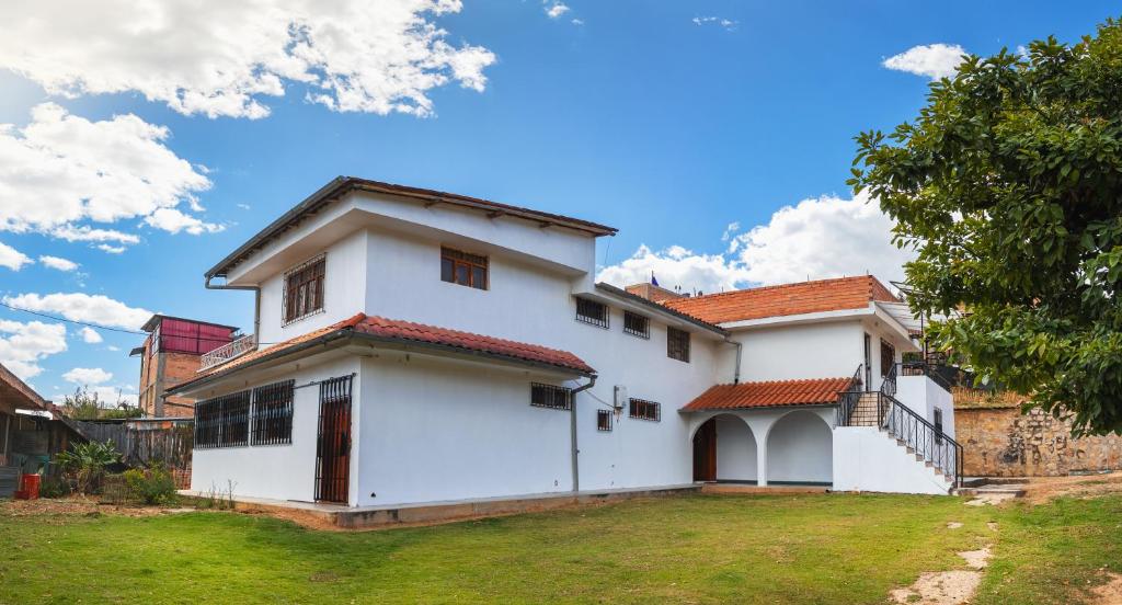 Casa blanca con techo rojo en Casa de campo Villa Acosta en Los Baños del Inca