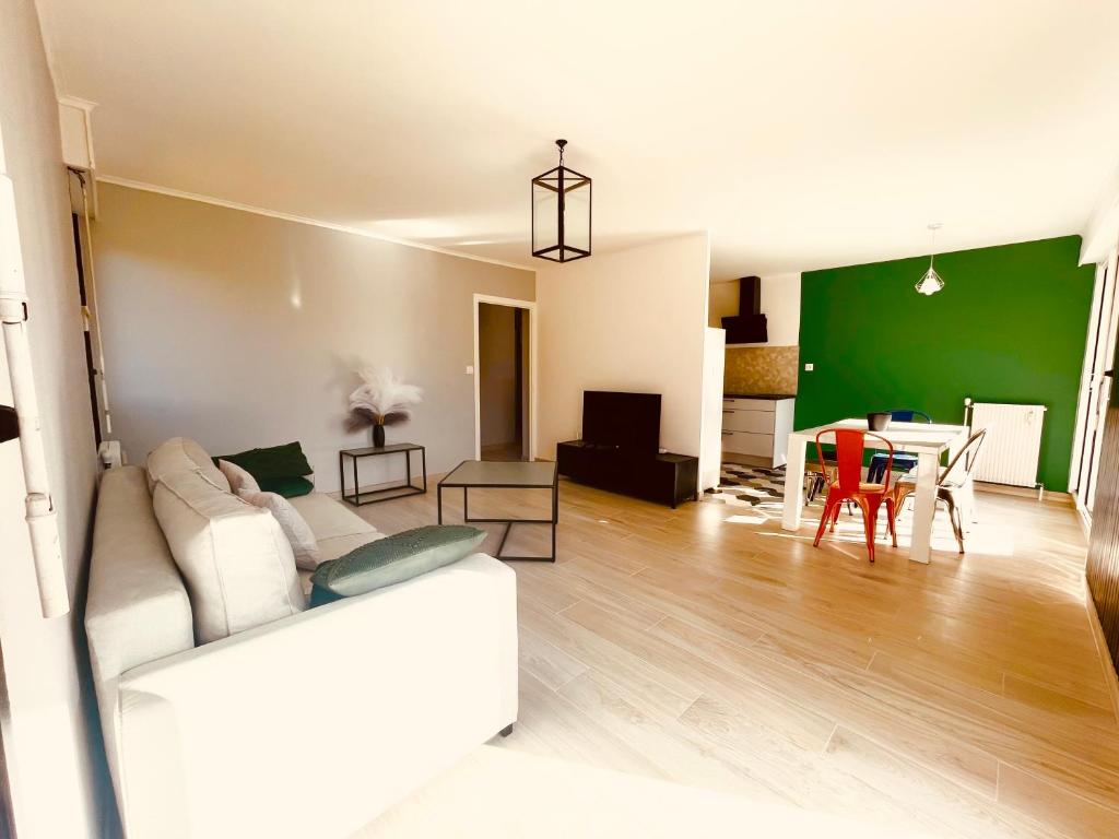 a living room with a white couch and a green wall at La montagne ça vous gagne ! in Cluses