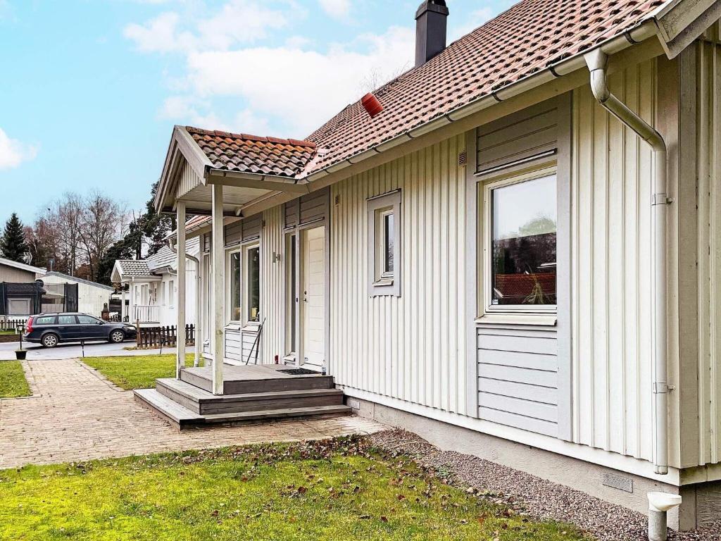 a small house with a porch and a window at Holiday home Björklinge in Björklinge