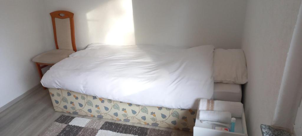 niewielka sypialnia z łóżkiem i krzesłem w obiekcie Messe Luxury room w Hanowerze