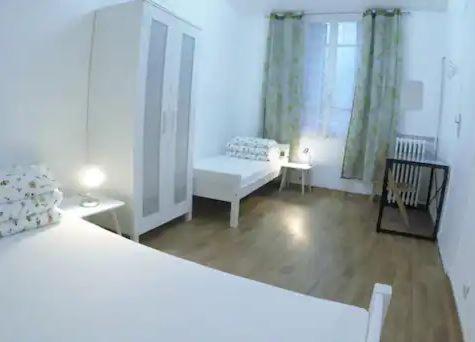 Habitación blanca con cama y sofá en Rose en Villejuif