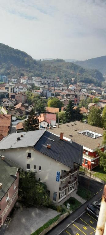 a white building with a blue roof in a city at Kineski zid in Zenica