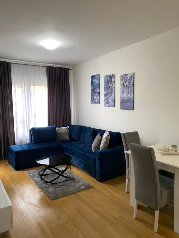 sala de estar con sofá azul y mesa en FALCON, en Banja Luka