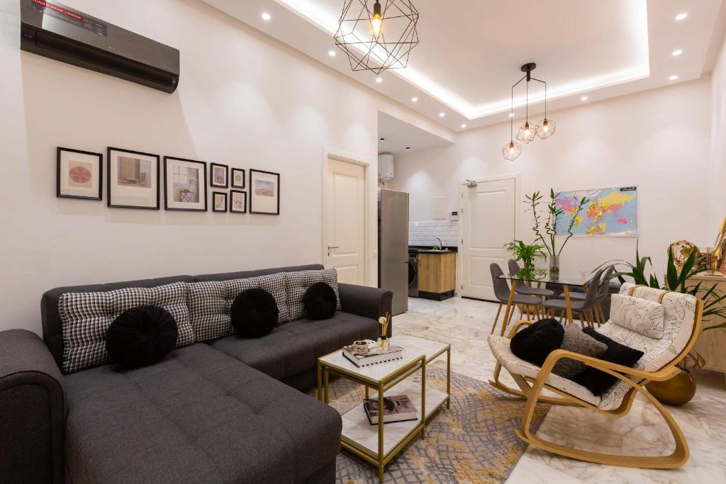 un soggiorno con divano, sedie e tavolo di Airport Apartment Suite Casablanca FREE WIFI Modern Confort Calme a Derroua
