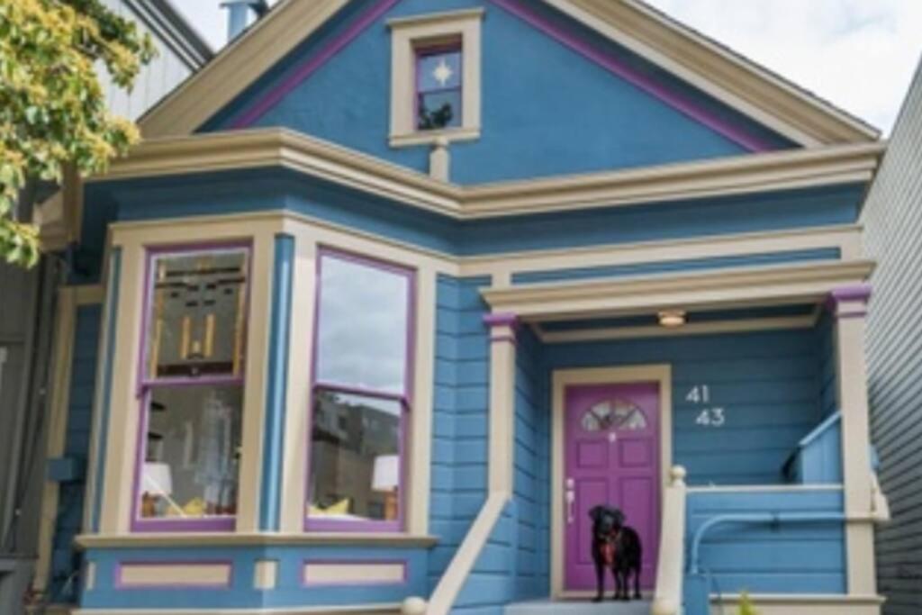 una casa azul con un perro parado fuera de ella en Sunny Victorian with Stunning View and Wraparound Deck en San Francisco