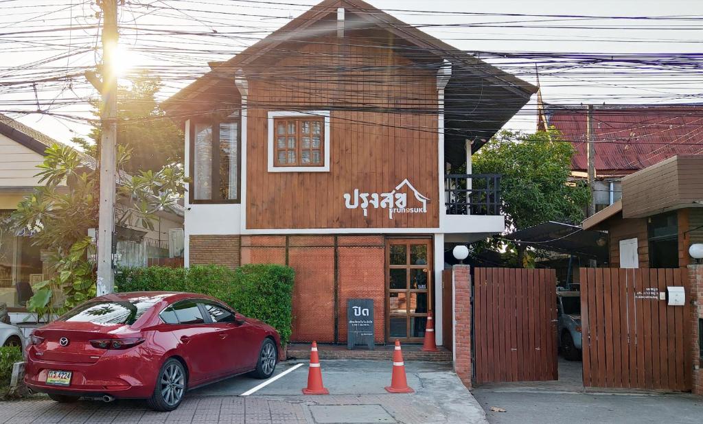 a red car parked in front of a building at ปรุงสุข in Phra Nakhon Si Ayutthaya