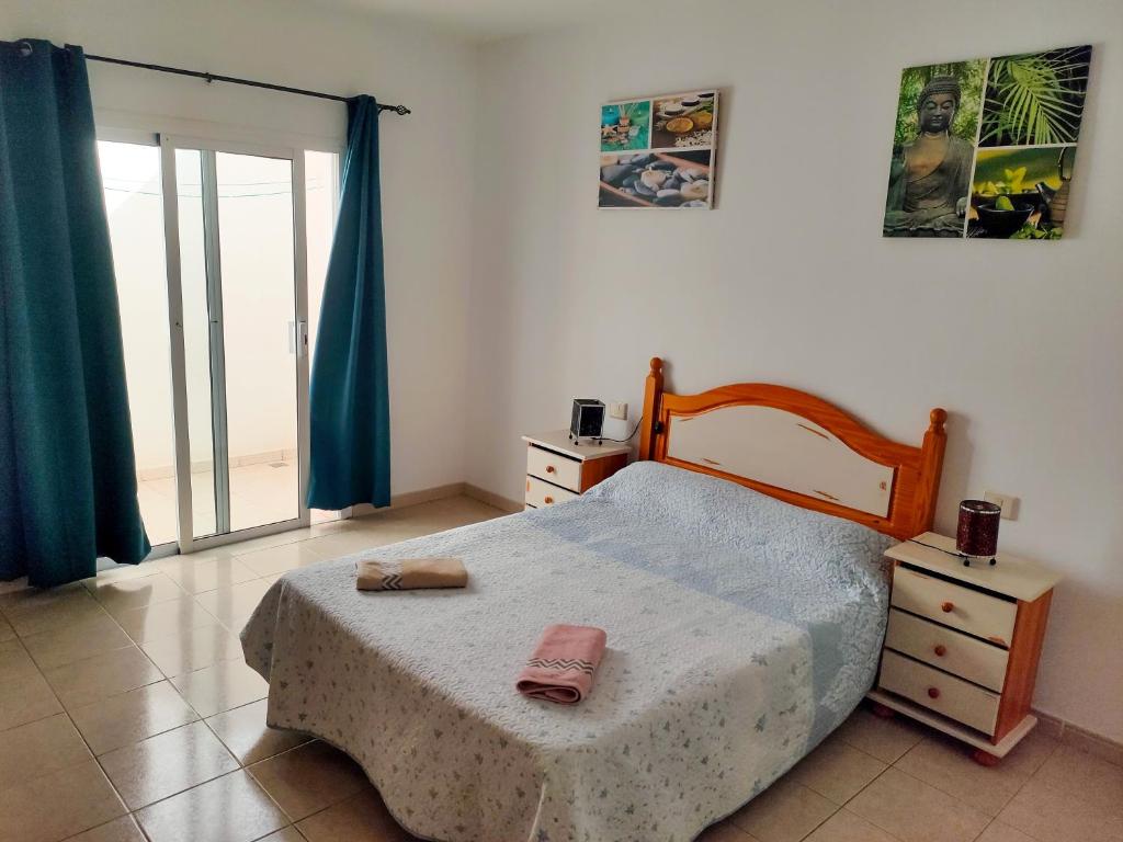 プエルト・デル・ロサリオにあるApartamento Céntrico Puerto Del Rosarioのベッドルーム1室(木製ヘッドボードと窓付)